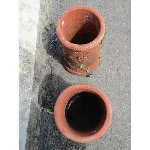 1191 - A pair of weathered terracotta chimney pots of squat cylindrical form with moulded rims, 46 cm high