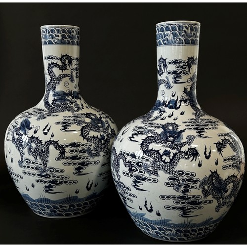 55 - A large pair of Chinese export blue and white porcelain floor-standing bottle vases with drawn cylin... 