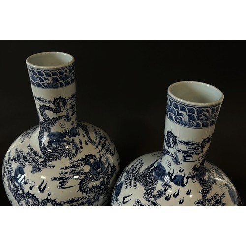 55 - A large pair of Chinese export blue and white porcelain floor-standing bottle vases with drawn cylin... 