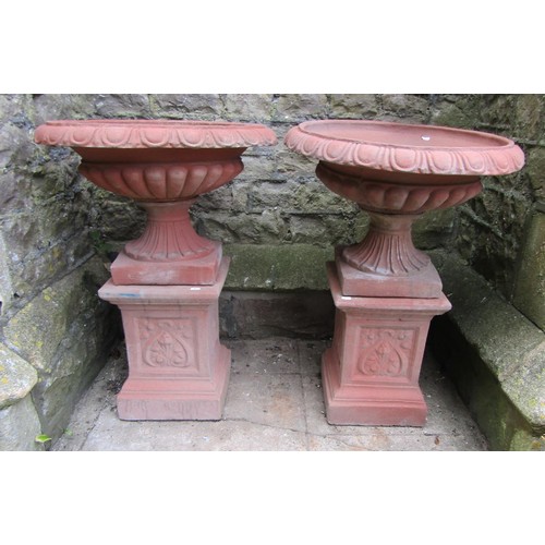 1215 - A pair of cast composition stone classical design faux terracotta garden urns, the squat circular lo... 