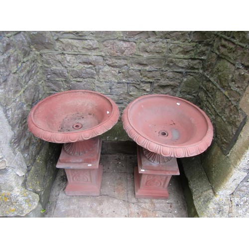 1215 - A pair of cast composition stone classical design faux terracotta garden urns, the squat circular lo... 