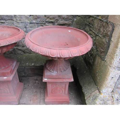 1215 - A pair of cast composition stone classical design faux terracotta garden urns, the squat circular lo... 