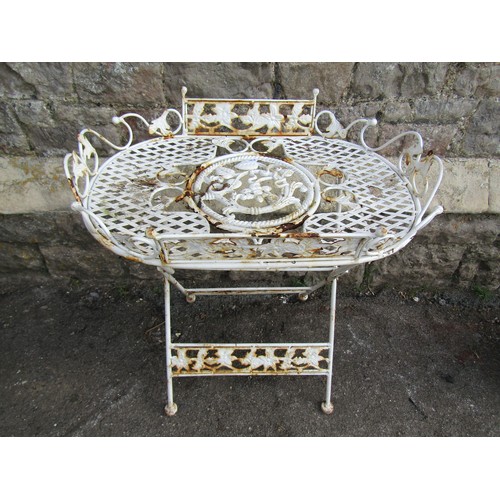 1203 - A small decorative folding garden/ conservatory table with lattice and scrolling foliate detail, 65c... 