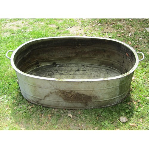 1229 - A vintage oval galvanised tin bath with simple flared rim and banded detail, 34 cm high x 103 cm x 6... 