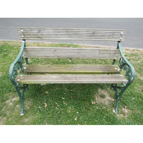 1234 - A two seat garden bench with boarded seat raised on painted cast iron end vine patterned supports, 1... 