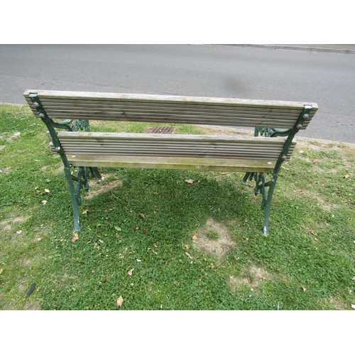 1234 - A two seat garden bench with boarded seat raised on painted cast iron end vine patterned supports, 1... 