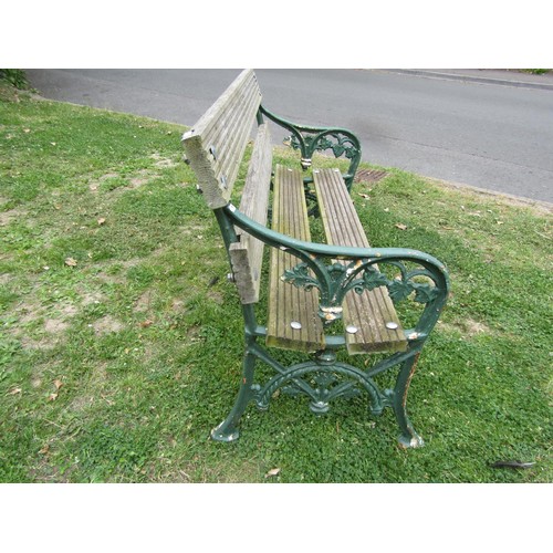 1234 - A two seat garden bench with boarded seat raised on painted cast iron end vine patterned supports, 1... 