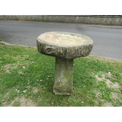 1238 - A weathered cast composition stone two sectional bird bath, the circular top with simulated bark boa... 