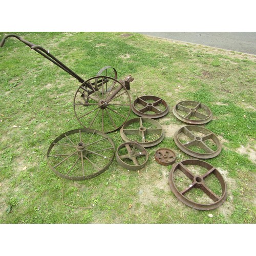 1241 - A Collection of vintage cast iron agricultural implement and further wheels together with a push hoe... 