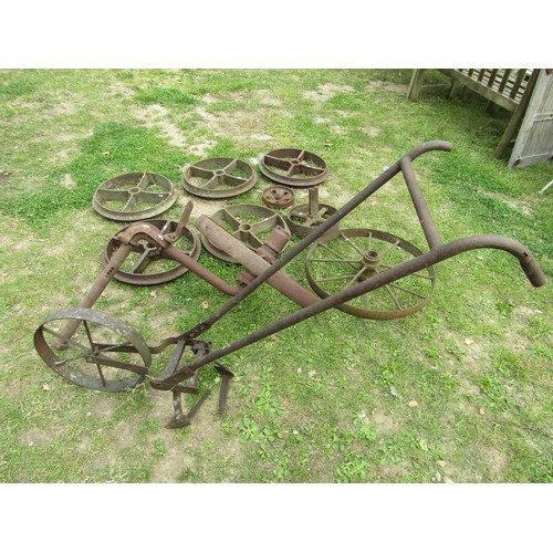 1241 - A Collection of vintage cast iron agricultural implement and further wheels together with a push hoe... 