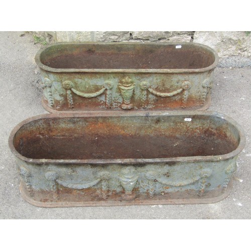 1275 - A Pair of weathered cast iron planters of elongated oval form with raised repeating classical urn an... 