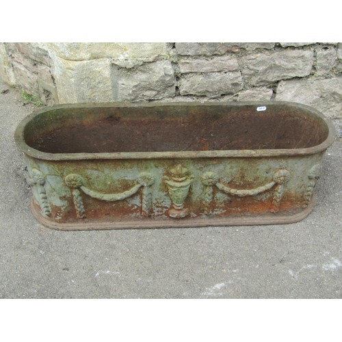 1275 - A Pair of weathered cast iron planters of elongated oval form with raised repeating classical urn an... 