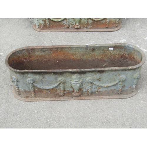 1275 - A Pair of weathered cast iron planters of elongated oval form with raised repeating classical urn an... 