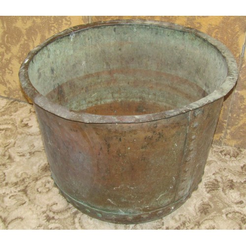 1283 - A large antique copper cauldron with flared rim and pot riveted seams, 58 cm high x 78 cm diameter