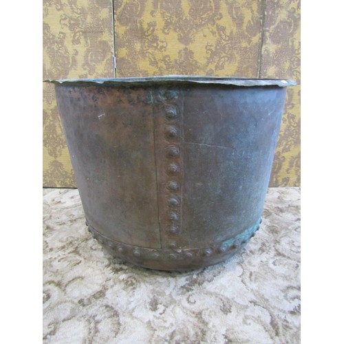 1283 - A large antique copper cauldron with flared rim and pot riveted seams, 58 cm high x 78 cm diameter