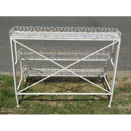 1250 - A decorative painted light steel three tier plant stand with simple strap work and open scroll detai... 