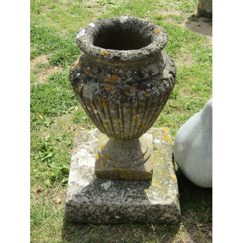 1251 - A weathered cast composition stone fluted square based urn raised on associated square platform base... 