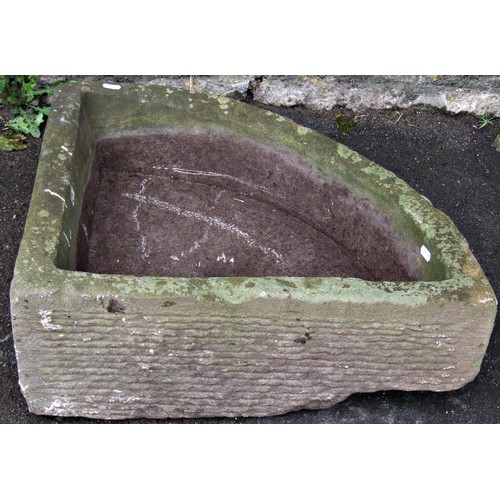 1292 - A weathered carved natural stone bow fronted corner trough with central circular drainage hole, 16 c... 