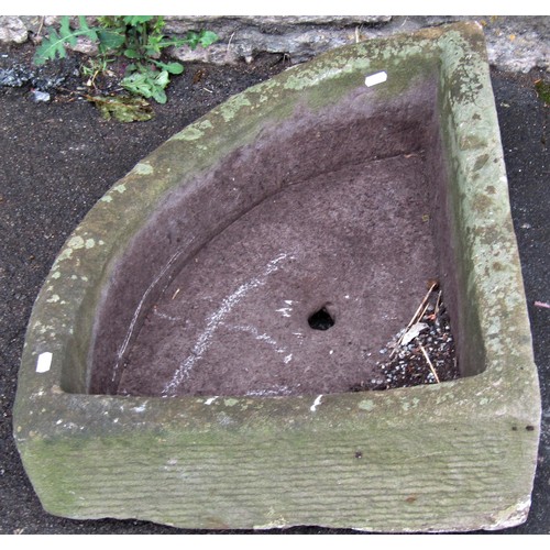 1292 - A weathered carved natural stone bow fronted corner trough with central circular drainage hole, 16 c... 