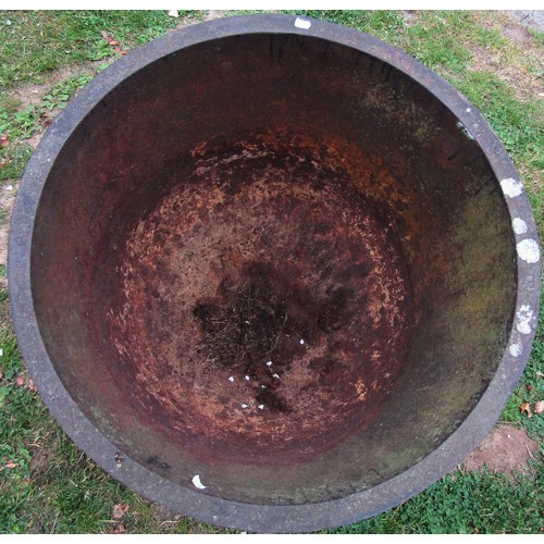 1260 - An old cast iron cauldron with flared rim and later drilled rounded base 56 cm high x 71 cm diameter