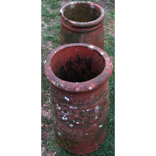 1210 - A weathered terracotta chimney/forcing pot of cylindrical tapering form 63 cm high together with a f... 