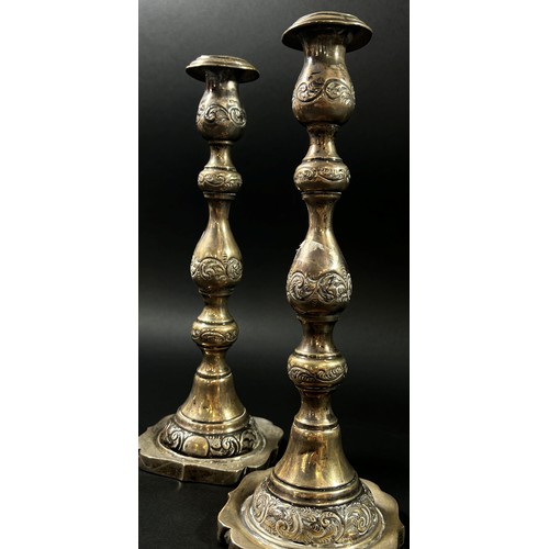 191 - A Pair of silver candlesticks in a scrolled vine design, London, 1925, makers mark rubbed, 28cm high... 