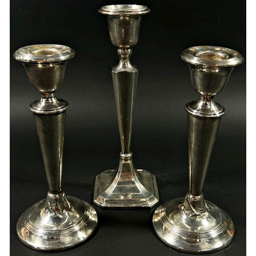 194 - A pair of silver 'V' shaped candlesticks, London, 1919, together with one other, Birmingham, 1923, m... 