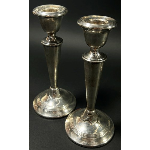 194 - A pair of silver 'V' shaped candlesticks, London, 1919, together with one other, Birmingham, 1923, m... 