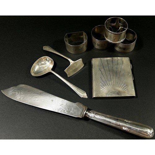 202 - A group of silver pieces to include four napkin rings an initialled silver cigarette case, a fish kn... 