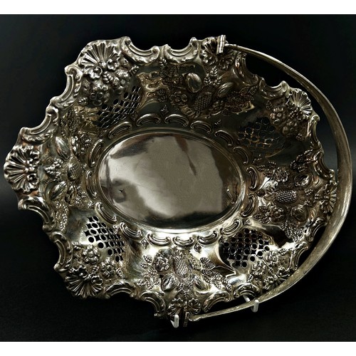 215 - A solid silver swing handle fruit basket in a floral and fruit decorated theme, London, 1900, makers... 