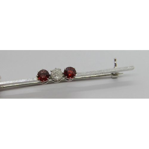 260 - Early 20th century 14ct white gold three stone bar brooch claw set with a diamond and two garnets, s... 