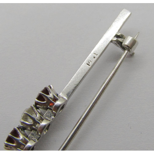 260 - Early 20th century 14ct white gold three stone bar brooch claw set with a diamond and two garnets, s... 