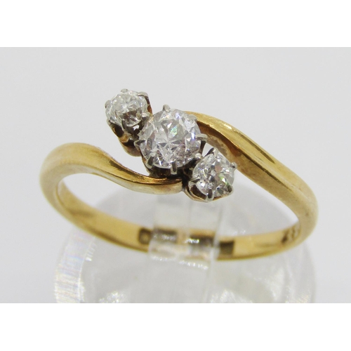 295 - 18ct three stone diamond crossover ring, centre stone 0.20ct approx, maker 'W&F.R', size K/L, 2.6g