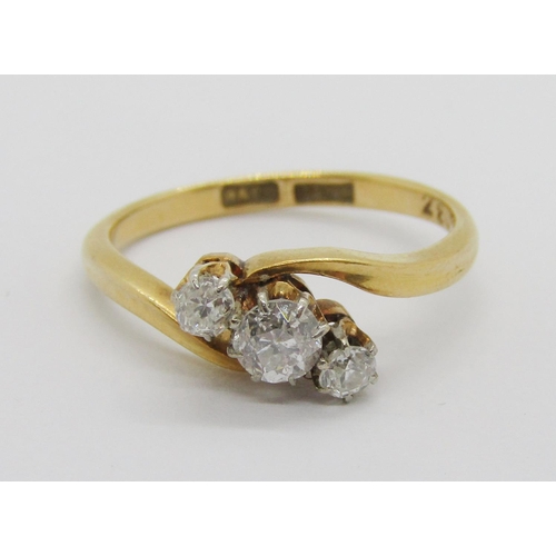 295 - 18ct three stone diamond crossover ring, centre stone 0.20ct approx, maker 'W&F.R', size K/L, 2.6g