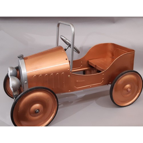 911 - A child's pedal car in good working order with copper coloured finish. Length 83cm