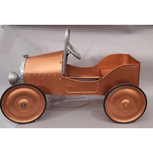 911 - A child's pedal car in good working order with copper coloured finish. Length 83cm