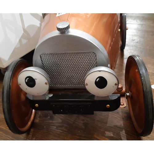 911 - A child's pedal car in good working order with copper coloured finish. Length 83cm