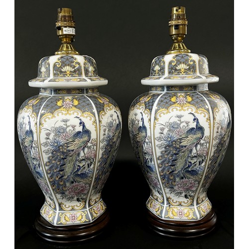 37 - A pair of decorative porcelain table lamps in the form of lidded vases decorated with Asiatic peacoc... 