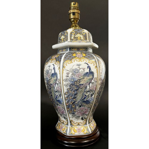 37 - A pair of decorative porcelain table lamps in the form of lidded vases decorated with Asiatic peacoc... 