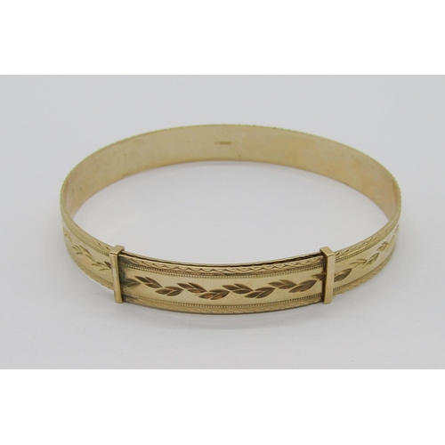 335 - 9ct adjustable bangle with engraved foliate decoration, maker 'LW', London, 16.4g