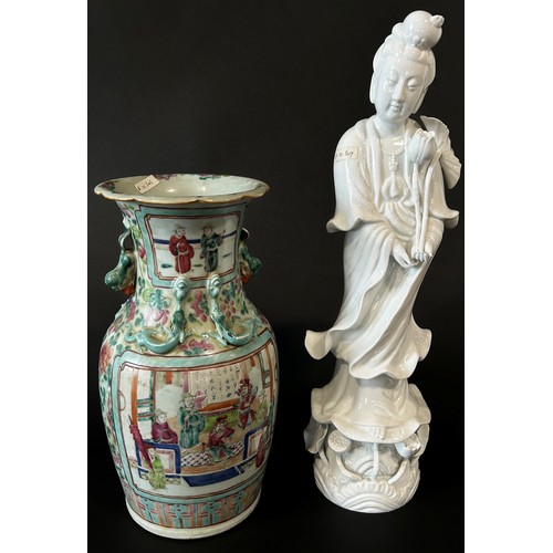 39 - A large Chinese blanc de chine figure of Guaynin, presented standing upon a Lotus pad, clutching Lot... 