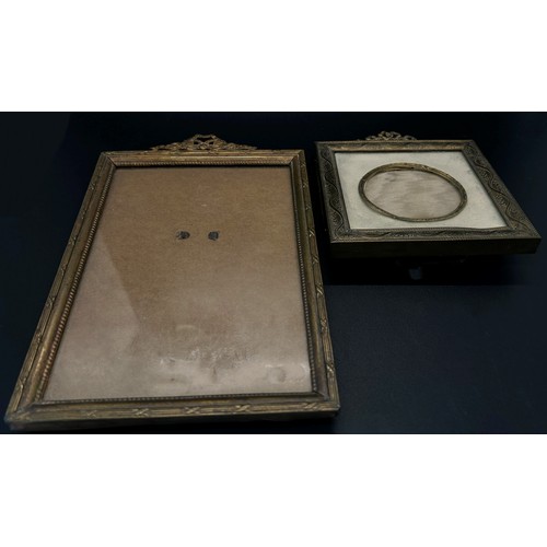 392 - An Edwardian cast brass two panel photograph frame with repeating geometric boarder beneath a ribbon... 