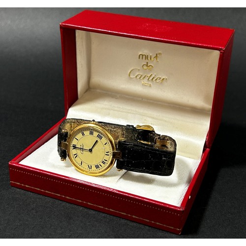 417 - Must de Cartier: A ladies silver gilt wristwatch, with Roman numerals on champaign dial, blue hands,... 