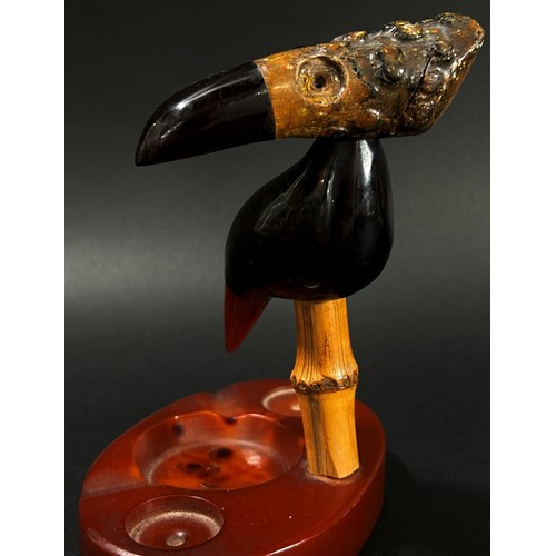 387 - A scarce Art Deco Y Z cherry amber Faturan Nut Bird ash tray, Henry Howell Dunhill, set on a composi... 