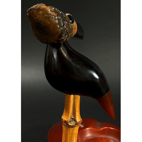 387 - A scarce Art Deco Y Z cherry amber Faturan Nut Bird ash tray, Henry Howell Dunhill, set on a composi... 