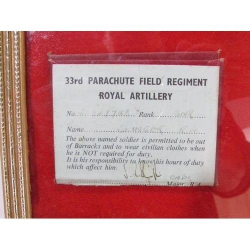 397 - A framed collection of 33rd Parachute Field Regiment Artillery cloth badges a gilded metal cap badge... 