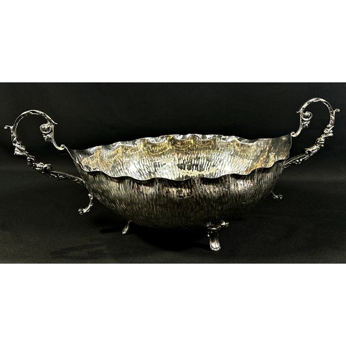 234 - A twin handled boat shaped silver dish with a hand finished worked surface, stamped do Silver Smith ... 