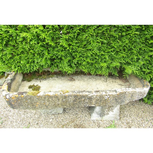 1001 - A shallow weathered natural stone planter / trough of rectangular form, raised on two associated sta... 