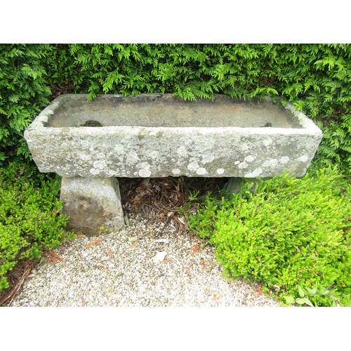 1003 - A weathered natural stone planter / trough of rectangular form, raised on a pair of associated stadd... 