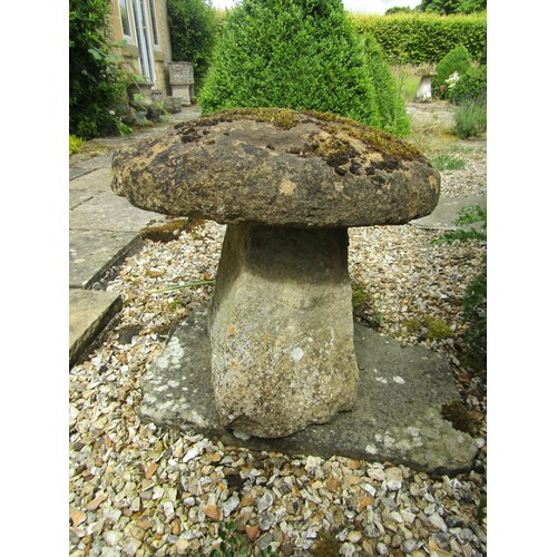 1019 - A low weathered natural stone staddle stone and cap, 56cm high, 67cm cap diameter approximately

Fro... 